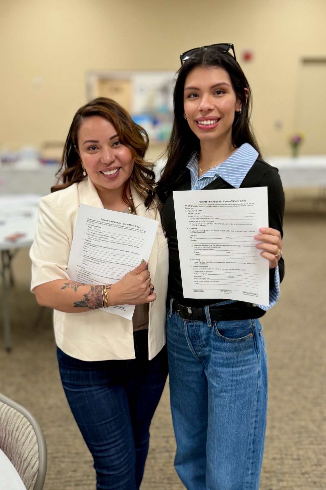 Dos mujeres sosteniendo documentos de preparación familiar en el evento de apoyo