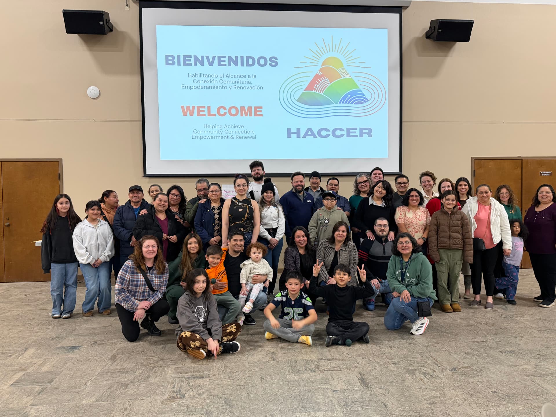 Familias y miembros de la comunidad reunidos en un encuentro comunitario de HACCER